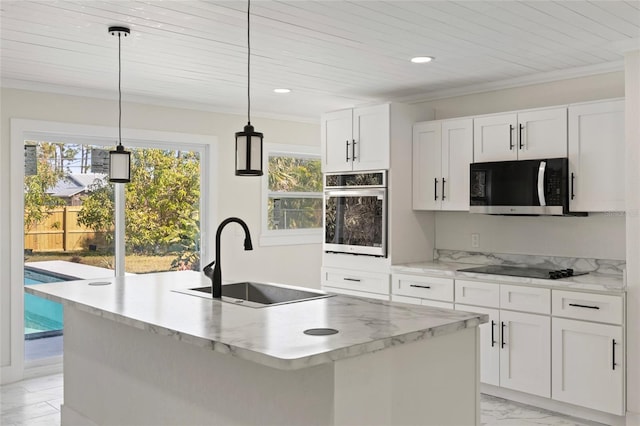 kitchen with sink, stainless steel appliances, an island with sink, white cabinets, and decorative light fixtures