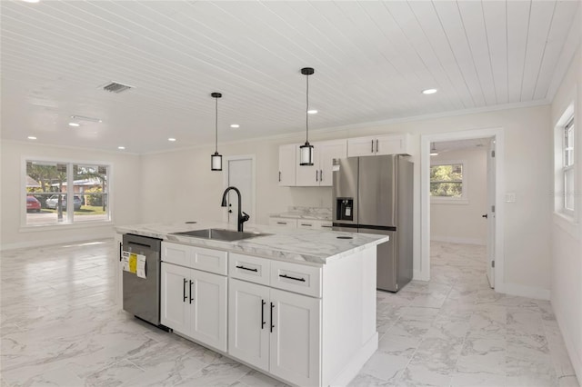 kitchen featuring sink, white cabinets, stainless steel appliances, light stone countertops, and a center island with sink