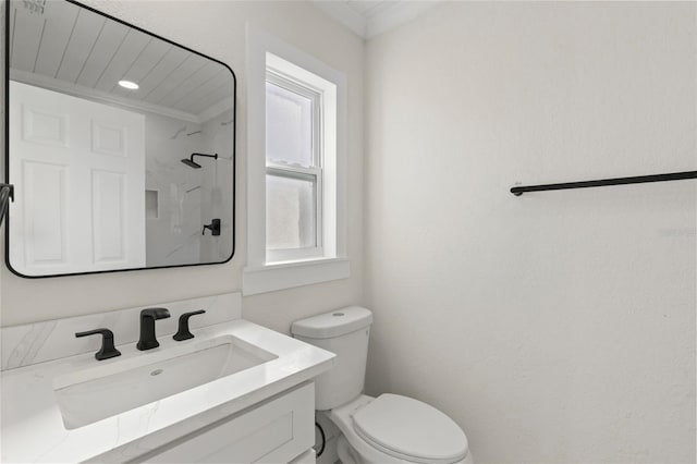 bathroom with crown molding, a shower, vanity, and toilet