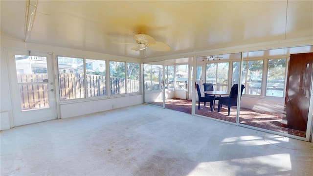 unfurnished sunroom with ceiling fan