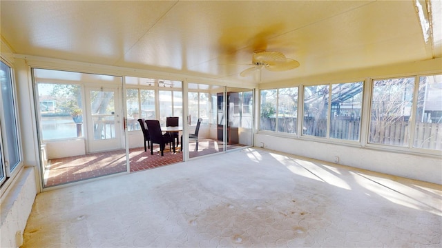 unfurnished sunroom with ceiling fan