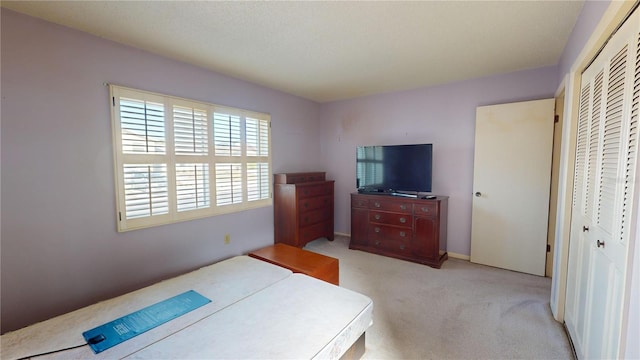 bedroom featuring light carpet and a closet