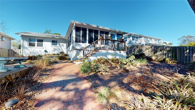 rear view of property featuring a sunroom