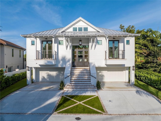 view of front of home featuring a garage, a balcony, ceiling fan, and french doors