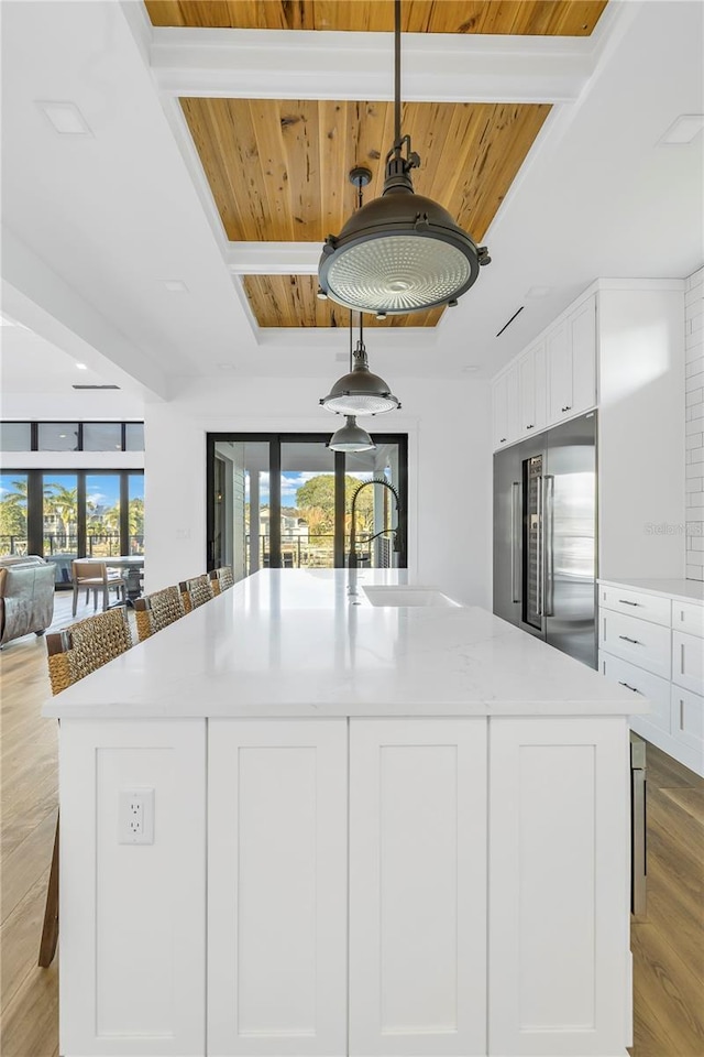 kitchen with a breakfast bar, decorative light fixtures, white cabinets, wood ceiling, and high end fridge