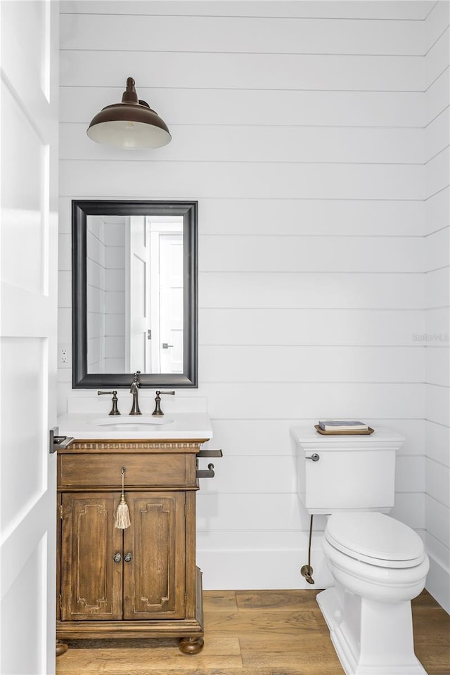 bathroom featuring hardwood / wood-style flooring, vanity, and toilet