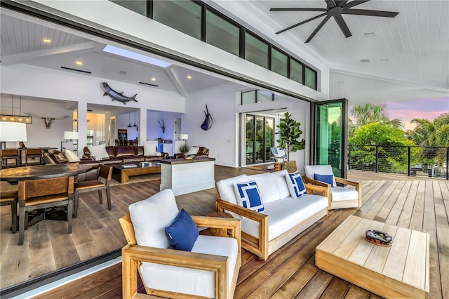 deck at dusk with outdoor lounge area and ceiling fan