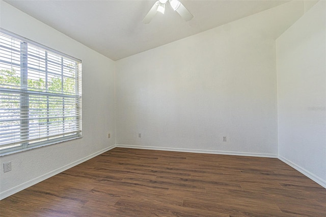 unfurnished room with vaulted ceiling, dark wood-type flooring, and a wealth of natural light