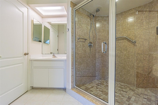 bathroom with tile patterned flooring, vanity, and a shower with shower door