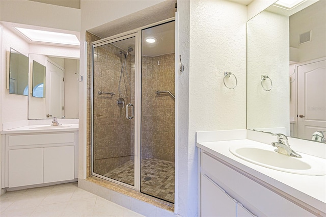 bathroom with an enclosed shower, vanity, and tile patterned floors