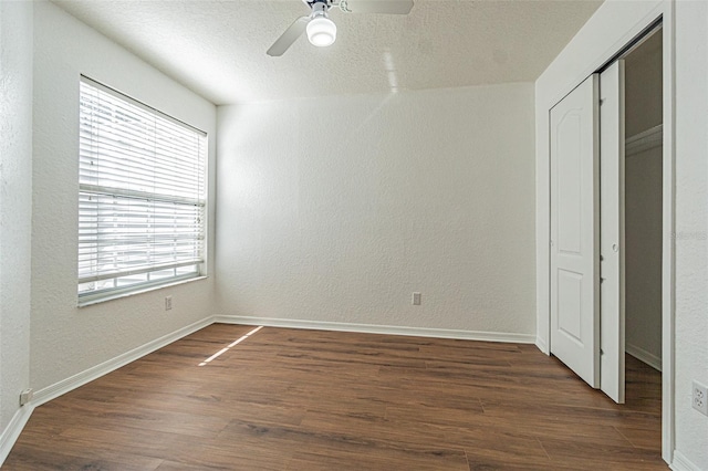 unfurnished bedroom with ceiling fan, dark hardwood / wood-style flooring, and a closet