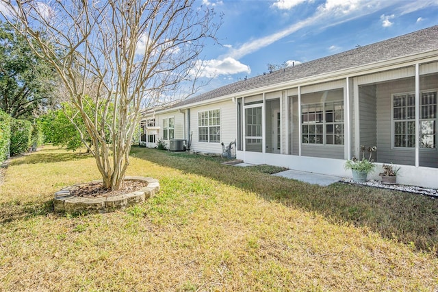 back of property featuring a yard, central AC unit, and a sunroom