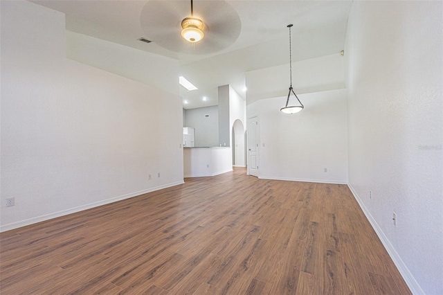 empty room featuring lofted ceiling, dark wood-type flooring, and ceiling fan