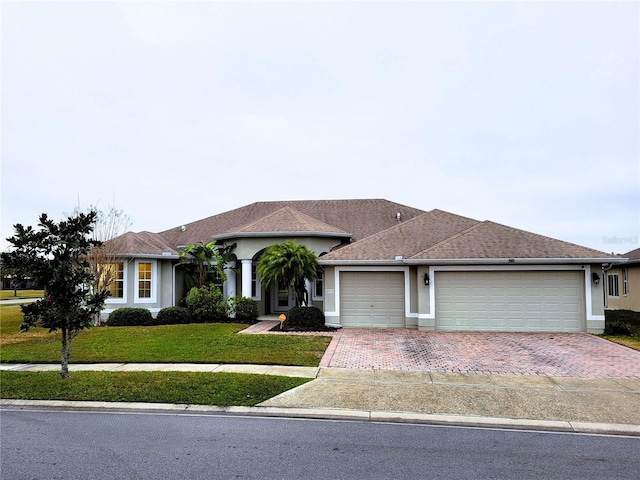 single story home featuring a garage and a front yard