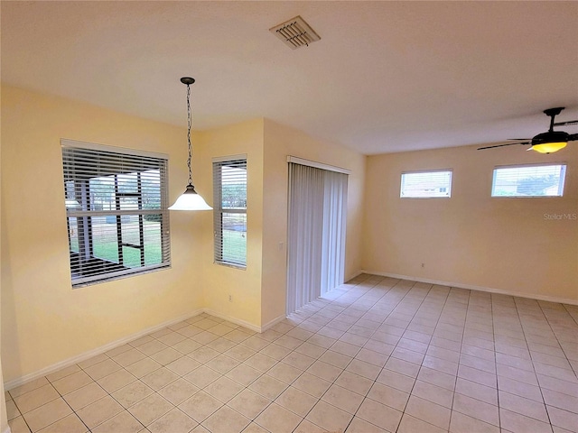 tiled spare room with ceiling fan