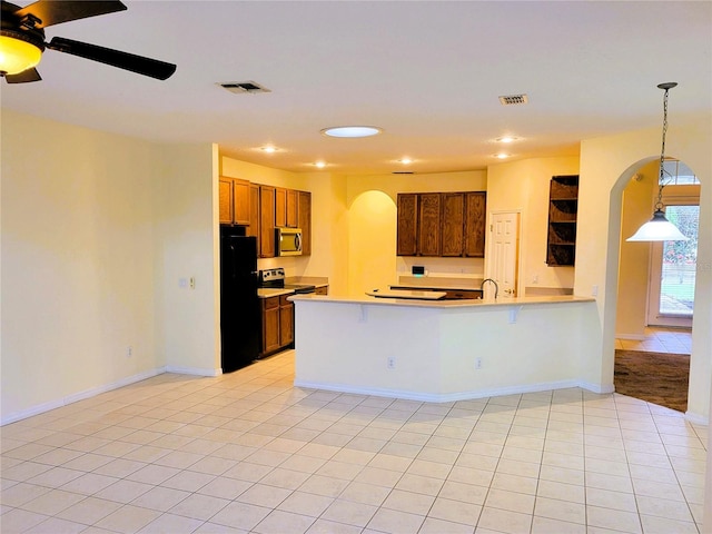 kitchen featuring decorative light fixtures, light tile patterned floors, ceiling fan, kitchen peninsula, and stainless steel appliances