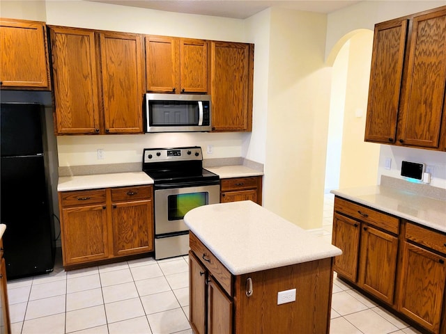 kitchen with stainless steel appliances, a center island, and light tile patterned floors