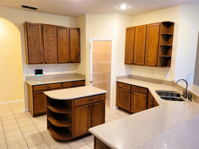 kitchen with sink, light tile patterned floors, and kitchen peninsula