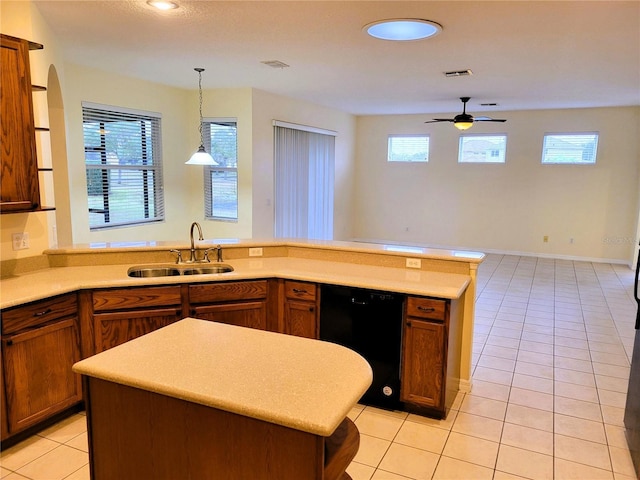 kitchen with decorative light fixtures, dishwasher, sink, and light tile patterned floors