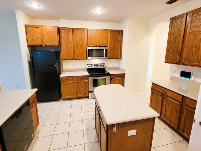 kitchen with black appliances, a center island, and light tile patterned flooring