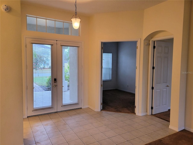 foyer entrance with light tile patterned floors and french doors