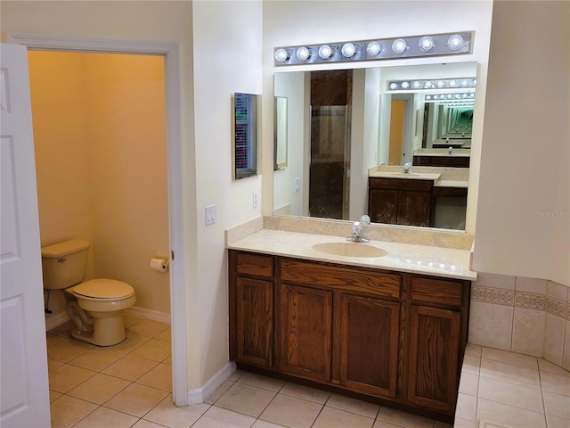 bathroom featuring tile patterned flooring, vanity, and toilet