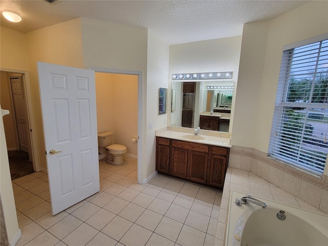 bathroom with vanity, a textured ceiling, tile patterned floors, a tub, and toilet