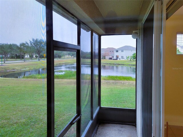 unfurnished sunroom featuring a water view