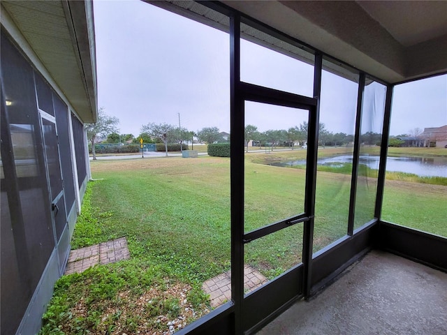 unfurnished sunroom featuring a water view