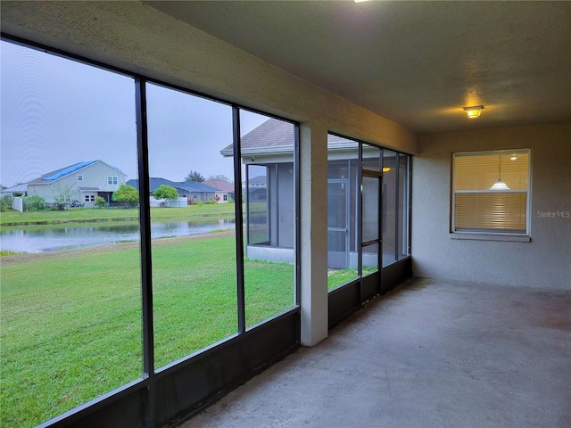 unfurnished sunroom with a water view