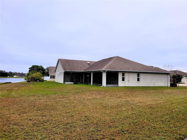 back of property featuring a water view and a yard