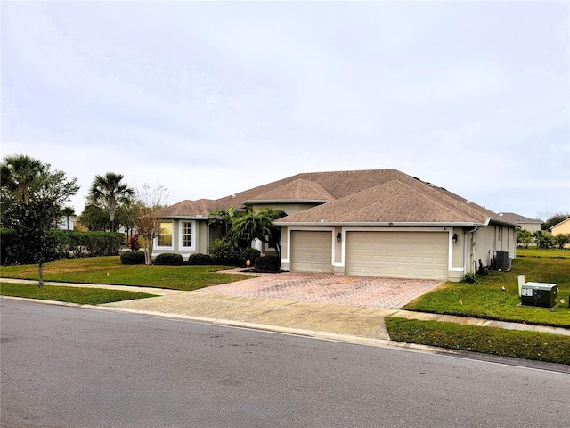 ranch-style home with cooling unit, a garage, and a front lawn