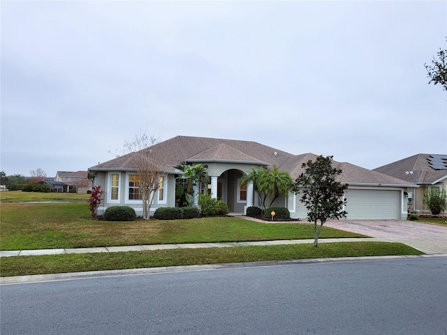 single story home with a garage and a front yard