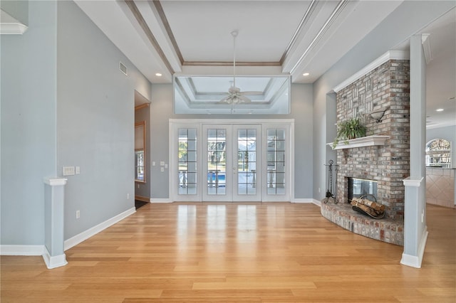 living room with crown molding, a tray ceiling, french doors, and a wealth of natural light