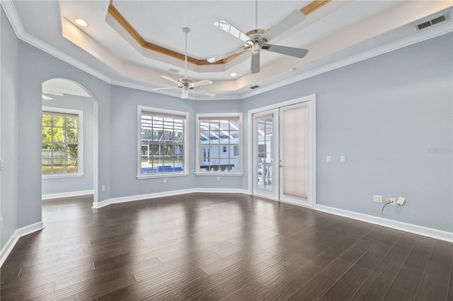 empty room with ceiling fan, ornamental molding, dark hardwood / wood-style flooring, and a raised ceiling