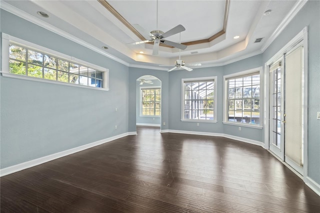 unfurnished room with crown molding, dark wood-type flooring, ceiling fan, and a tray ceiling