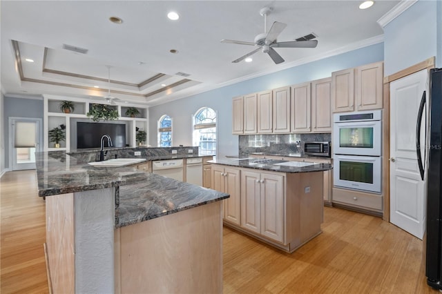 kitchen with sink, white appliances, dark stone countertops, a center island, and kitchen peninsula