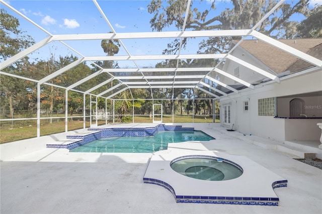 view of pool featuring an in ground hot tub, glass enclosure, and a patio area