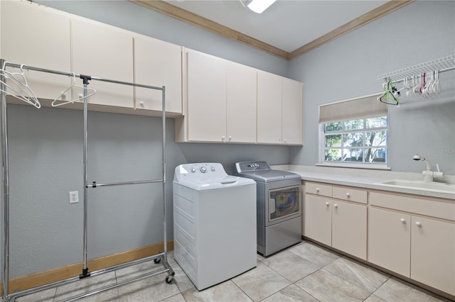 washroom with sink, light tile patterned floors, cabinets, independent washer and dryer, and ornamental molding