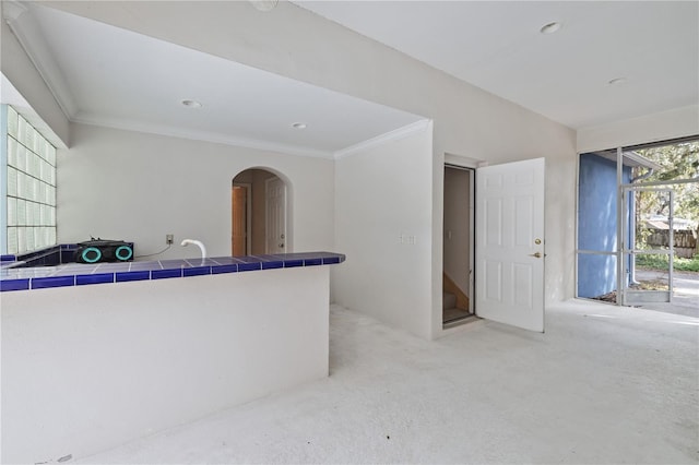 interior space featuring crown molding and tile countertops