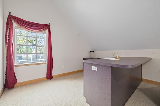 interior space featuring light colored carpet, lofted ceiling, and sink