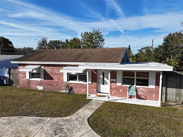 ranch-style house with covered porch and a front yard