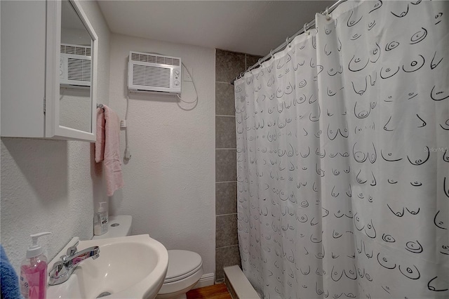 bathroom featuring toilet, sink, wood-type flooring, a wall mounted AC, and curtained shower