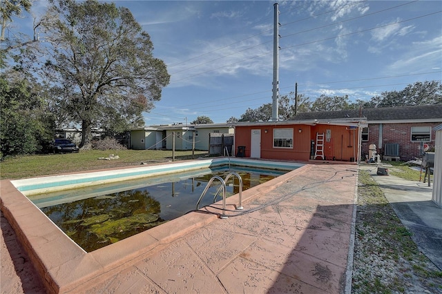 view of pool featuring cooling unit and a lawn