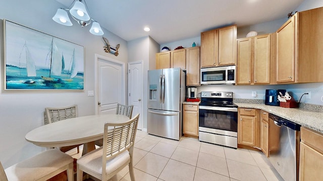 kitchen featuring pendant lighting, appliances with stainless steel finishes, light brown cabinets, and light tile patterned floors