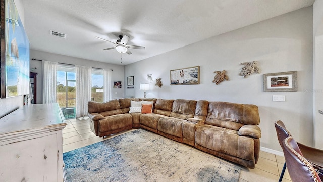 living room featuring light tile patterned floors, a textured ceiling, and ceiling fan