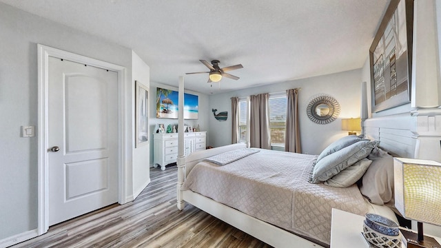 bedroom with hardwood / wood-style floors, a textured ceiling, and ceiling fan