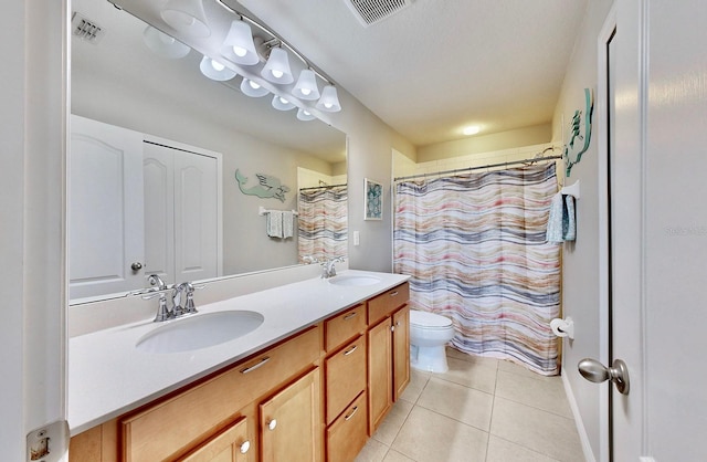 bathroom with tile patterned floors, vanity, toilet, and curtained shower