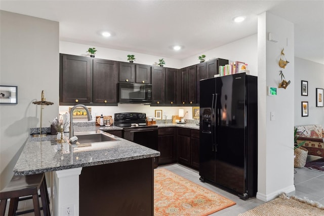 kitchen with stone countertops, sink, black appliances, light tile patterned flooring, and kitchen peninsula