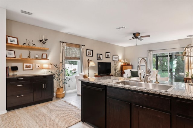 kitchen featuring plenty of natural light, sink, and light stone counters